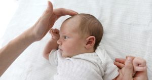 médico examinando moleira de bebê com microcefalia